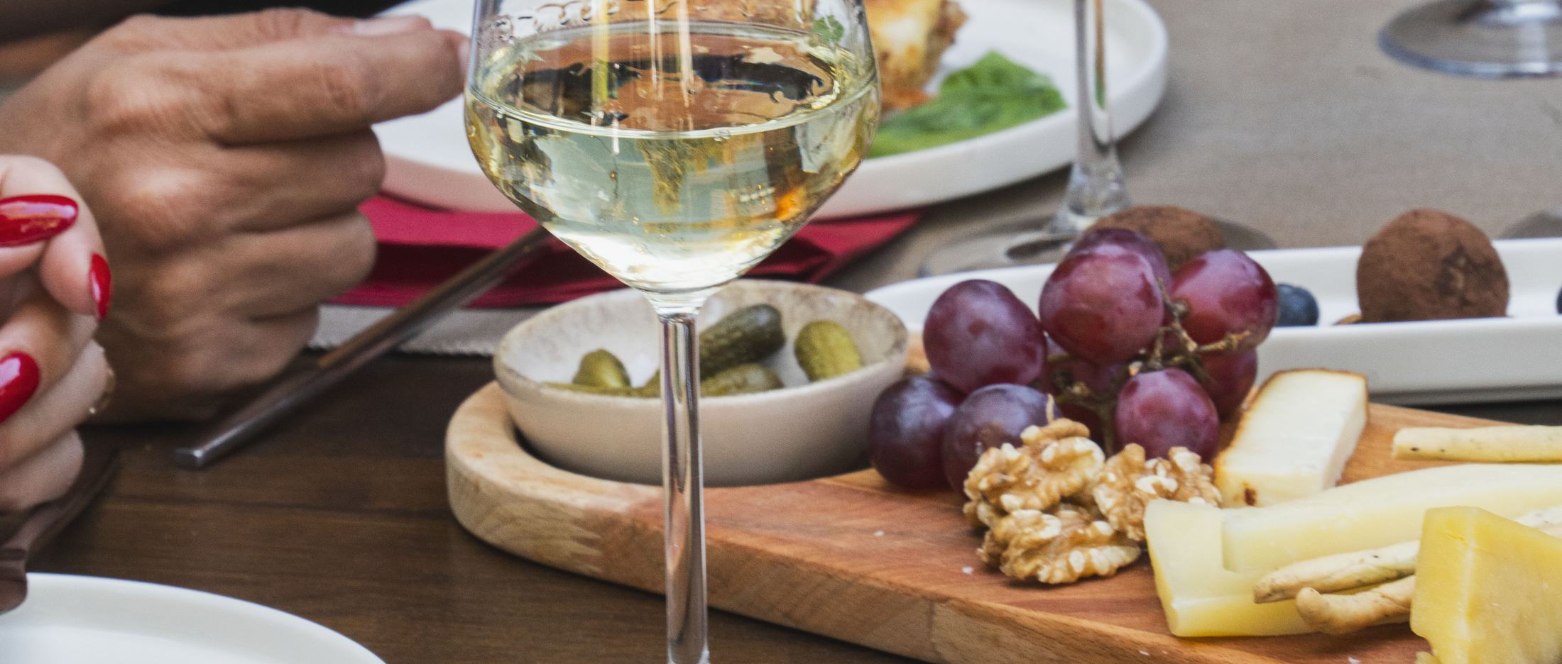 Tagliere di formaggi e salumi con vino bianco