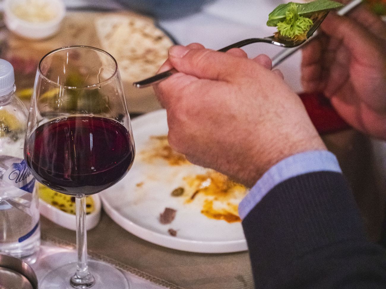 Degustazione al tavolo con un calice di vino rosso