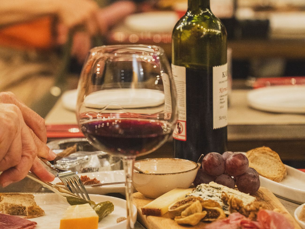 Tagliere di formaggi con bottiglia e calice di vino